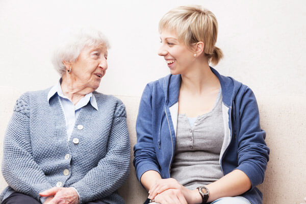 Female social worker talks to an elderly woman