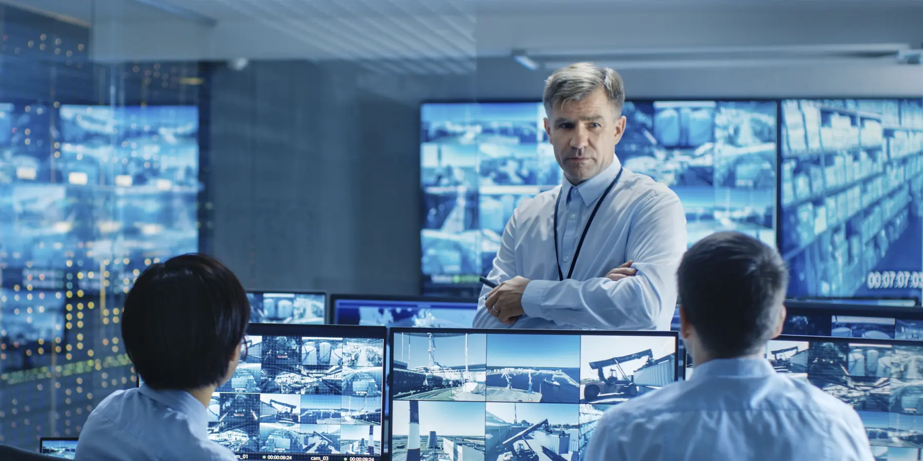 Men discussing around many computer monitors