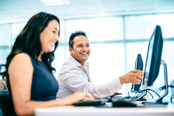 A male and female student using computers