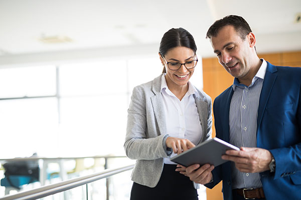 Two managers look at information on a tablet