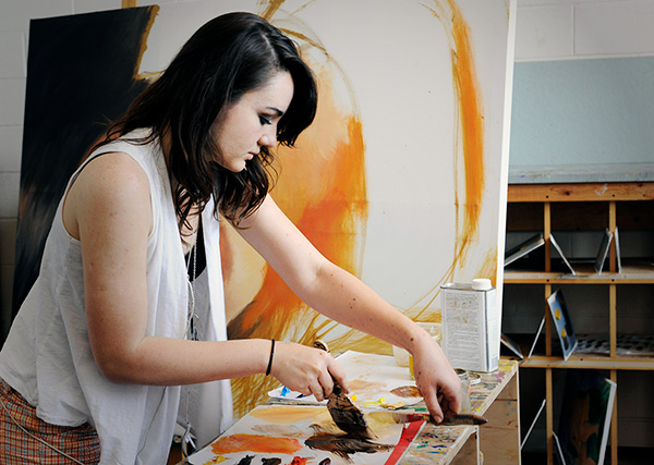 A female art student painting in the classroom