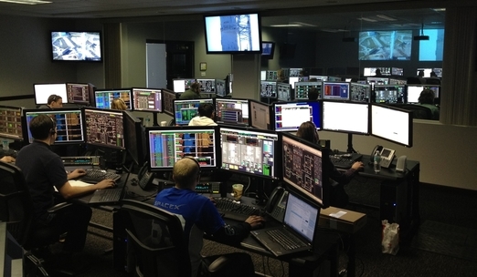 Emergency management control room with people working at a number of screens